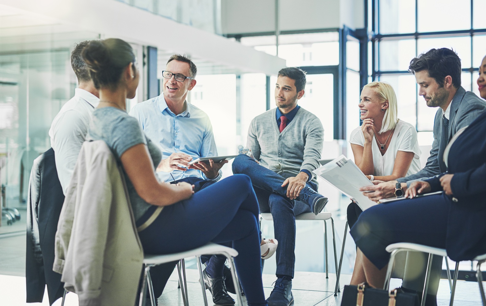 Group of business people sitting in a circle talking together and sharing ideas